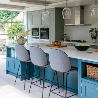 Kitchen with green cabinetry and bright blue island