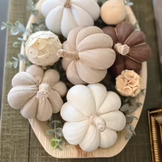 Neutral sock pumpins arranged on a table with faux flowers and plants