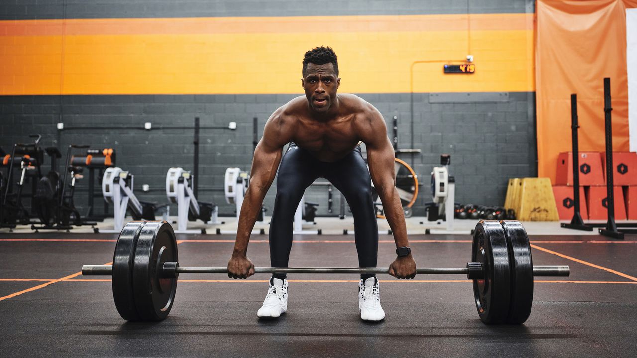 Man Working Out in a Gym with Barbell and Weights