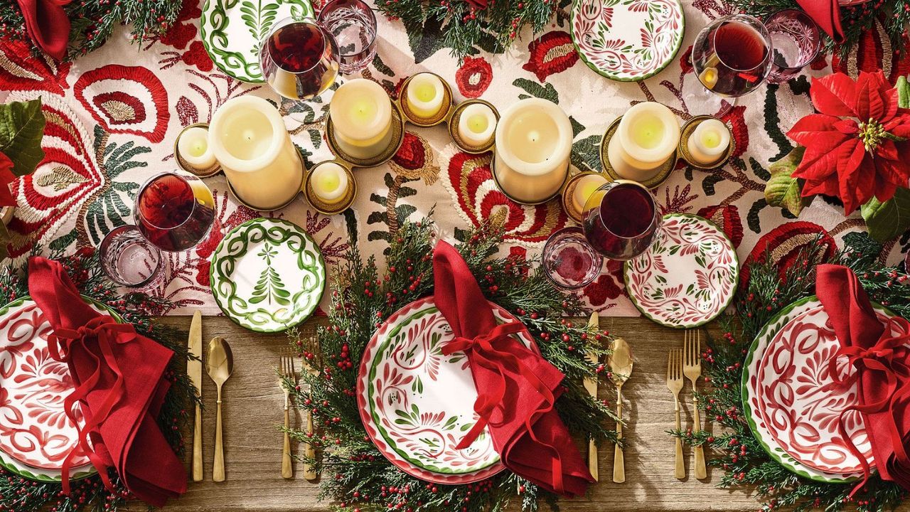 Christmas table with wreath chargers, green and red dinnerware, and gold cutlery