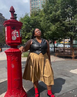 Editor Chinazor Offor in beige skirt and black vest.