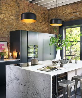 industrial kitchen with marble kitchen island and exposed brcik