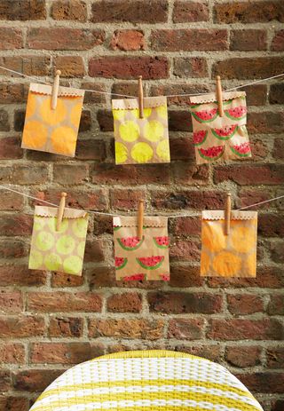 painted paper goodie bags hanging from pegs at party