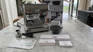 silver coffee machine on counter with accessories laid out