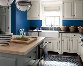 kitchen with white cabinets, dark blue wall and wooden kitchen island