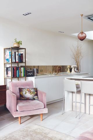 pink velvet armchair in white kitchen