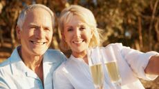 Senior couple celebrating with some champagne outdoors