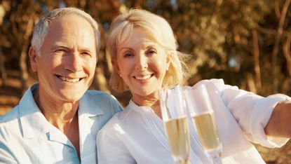 Senior couple celebrating with some champagne outdoors