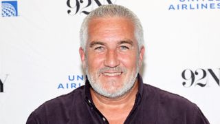 Paul Hollywood wearing a black shirt and smiling 