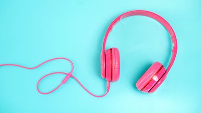 pink headphone on light Blue background,vintage or pastel concept