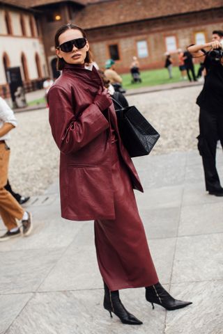 woman wearing oversized leather jacket, leather skirt, black boots