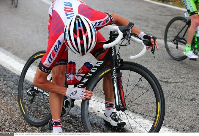 A Katusha rider adjusts his bike after a crash