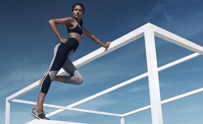 Gym gear worn by lady standing on white wooden frame