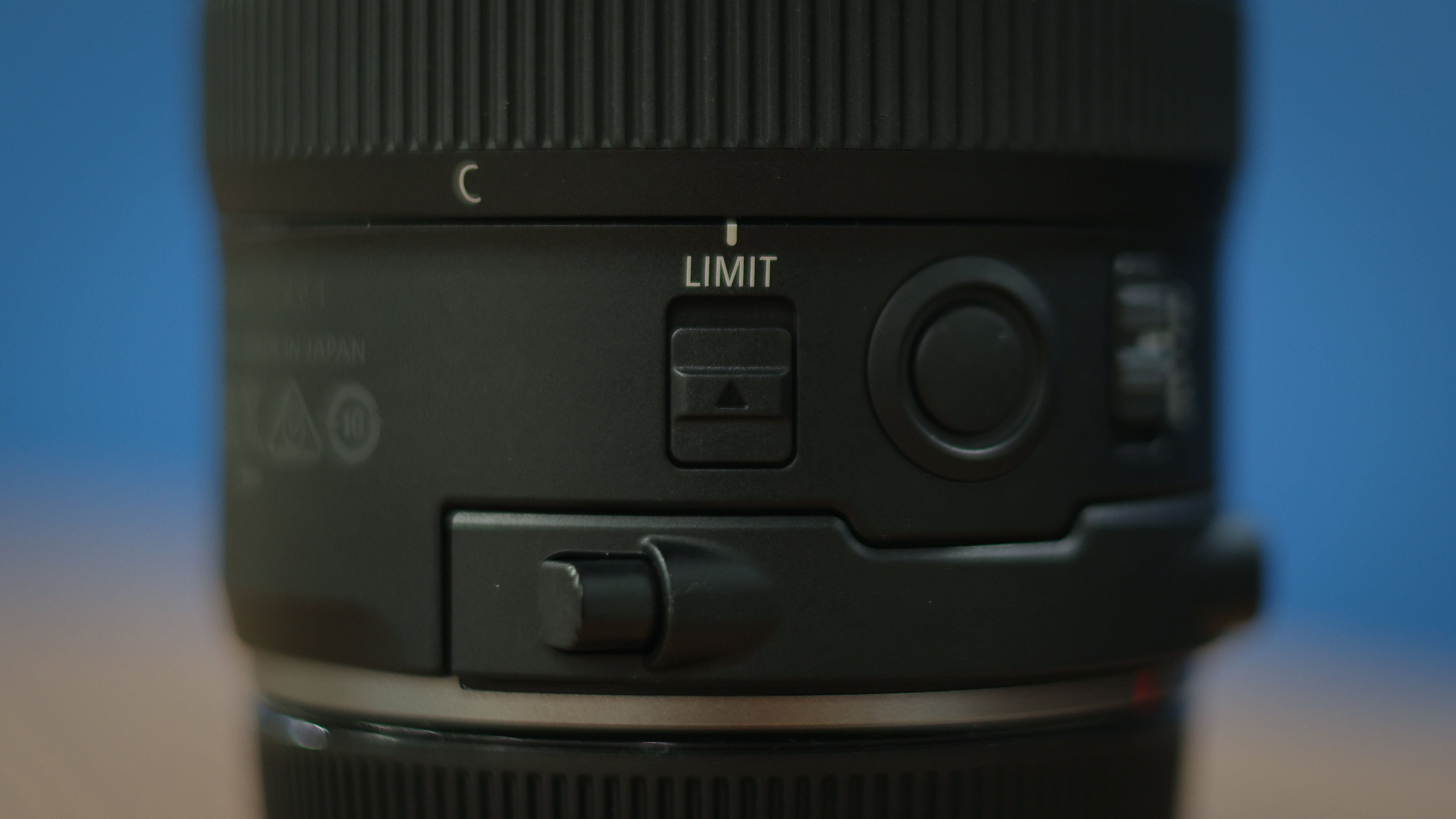 Canon RF 7-14mm f/2.8-3.5L Fisheye STM on a wooden surface in front of a blue background