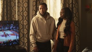 Emmett (Jacob Latimore) and Kiesha (Birgundi Baker) stand apprehensively together in the middle of their living room in "The Chi" season 7.