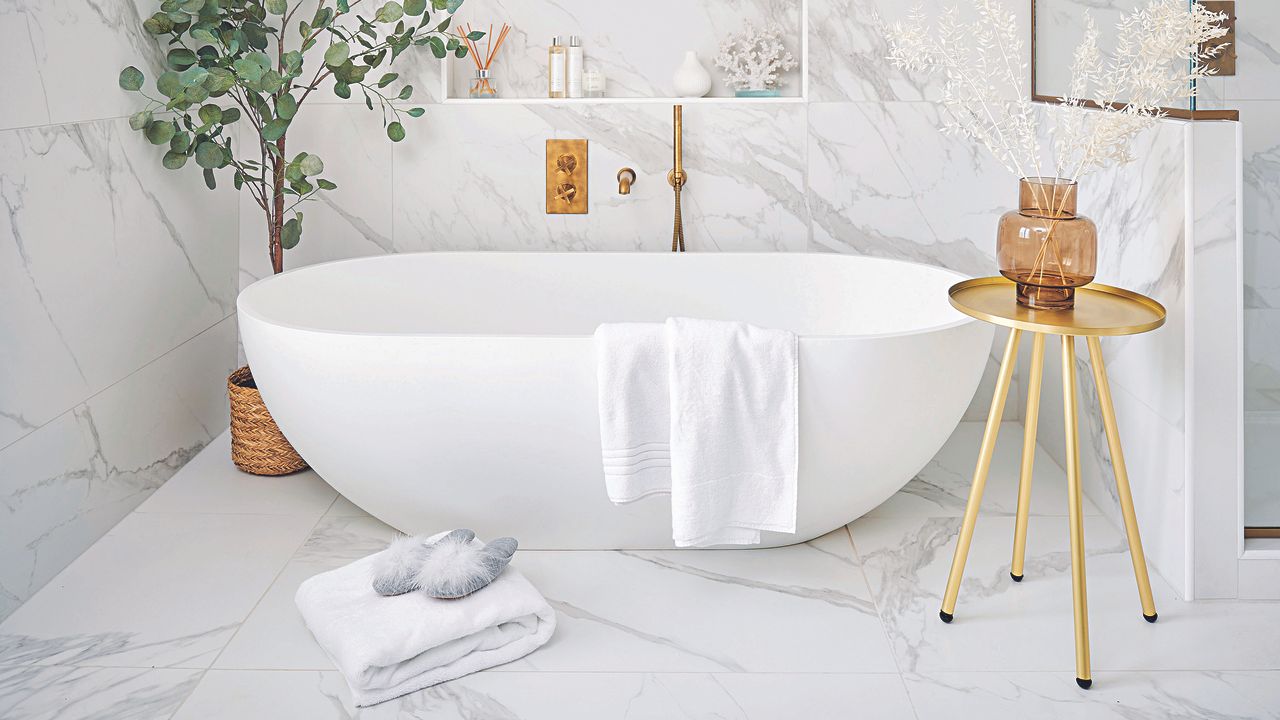 White bathroom with freestanding bath and gold hardware