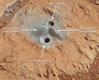 The first drill holes on Mars by NASA's Curiosity rover are seen in this image taken by the rover on March 29, 2013 at the John Klein rock in the Yellowknife Bay area of Mars' Gale Crater.
