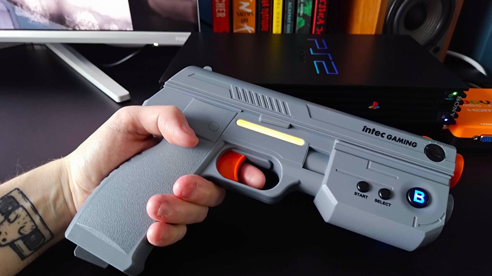 Hand holding Intec Time Breaker Lightgun to the side with yellow battery indicator strip in view.