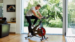 Man uses one of the best budget exercise bikes in his home