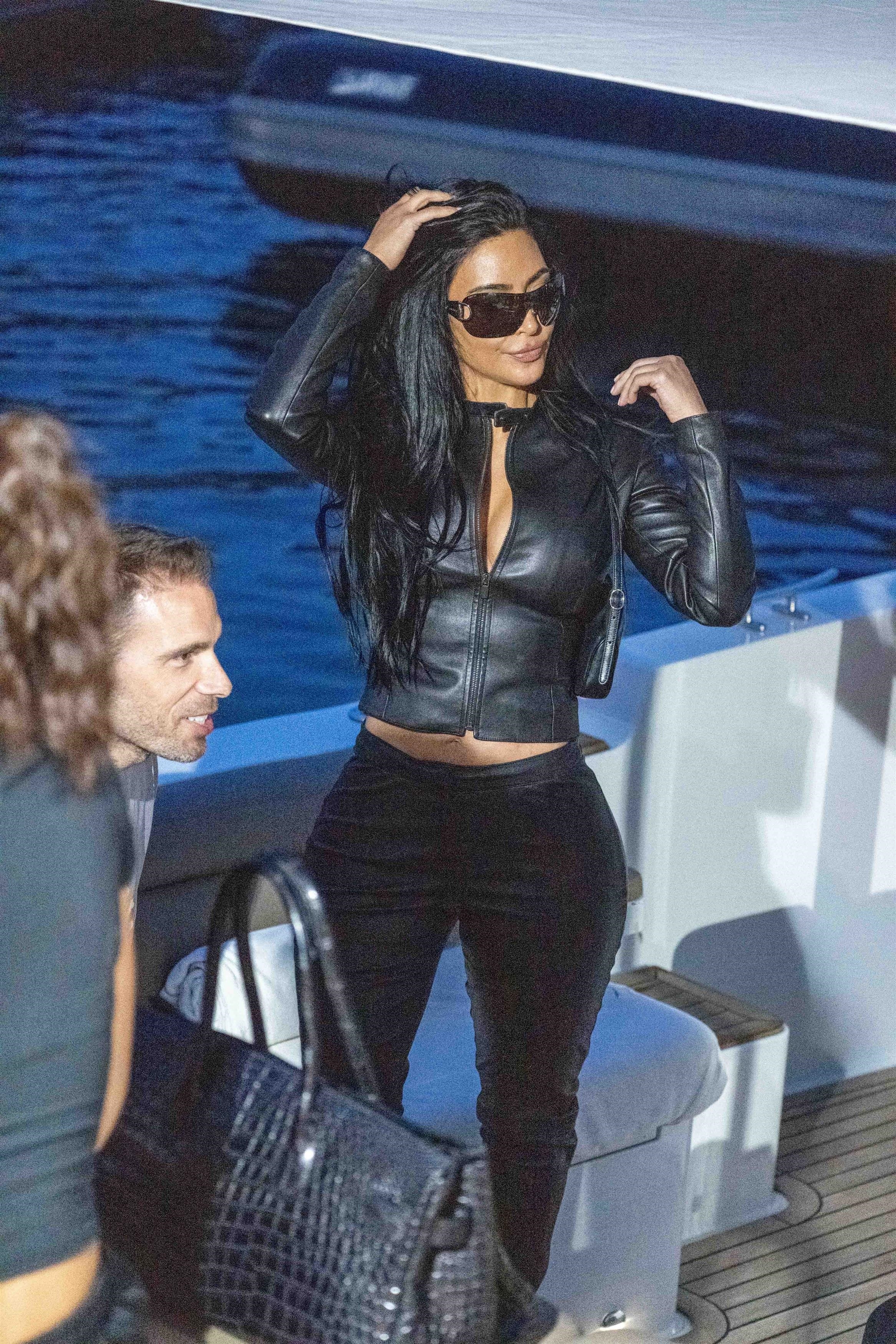 Kim Kardashian wears a two-piece leather Gucci racing suit and carries a matching Gucci bag to support boyfriend Lewis Hamilton at the Monaco Grand Prix