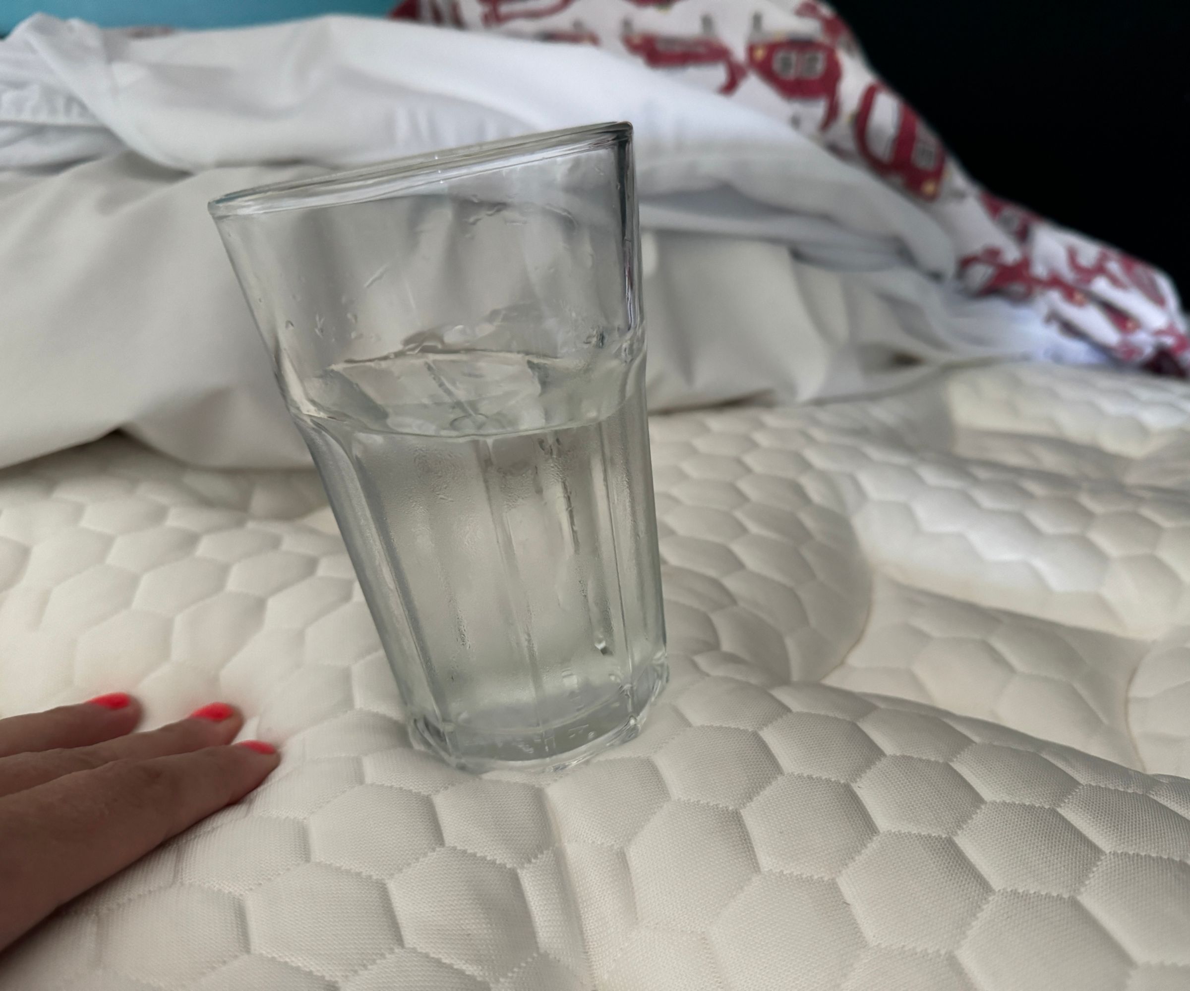 A glass of water balanced on the Helix Dusk Mattress.