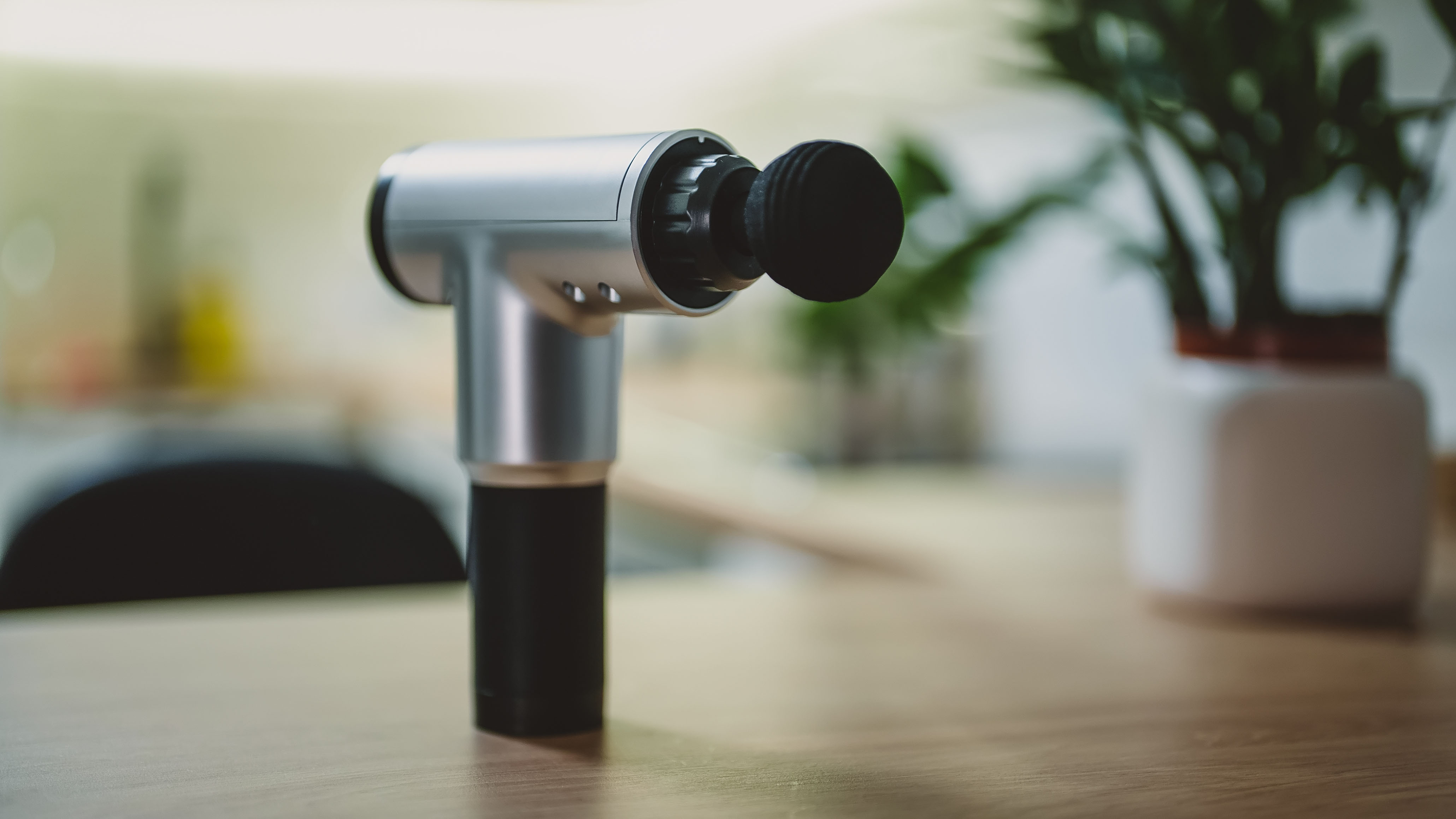 Massage gun stood upright on table