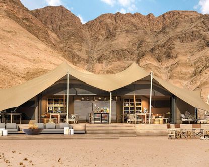 tent house with grey sofa and chairs surrounding mountains