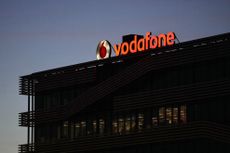 A sign on the roof of the Vodafone Group Plc regional headquarters at night in Madrid, Spain.