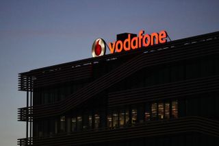A sign on the roof of the Vodafone Group Plc regional headquarters at night in Madrid, Spain.