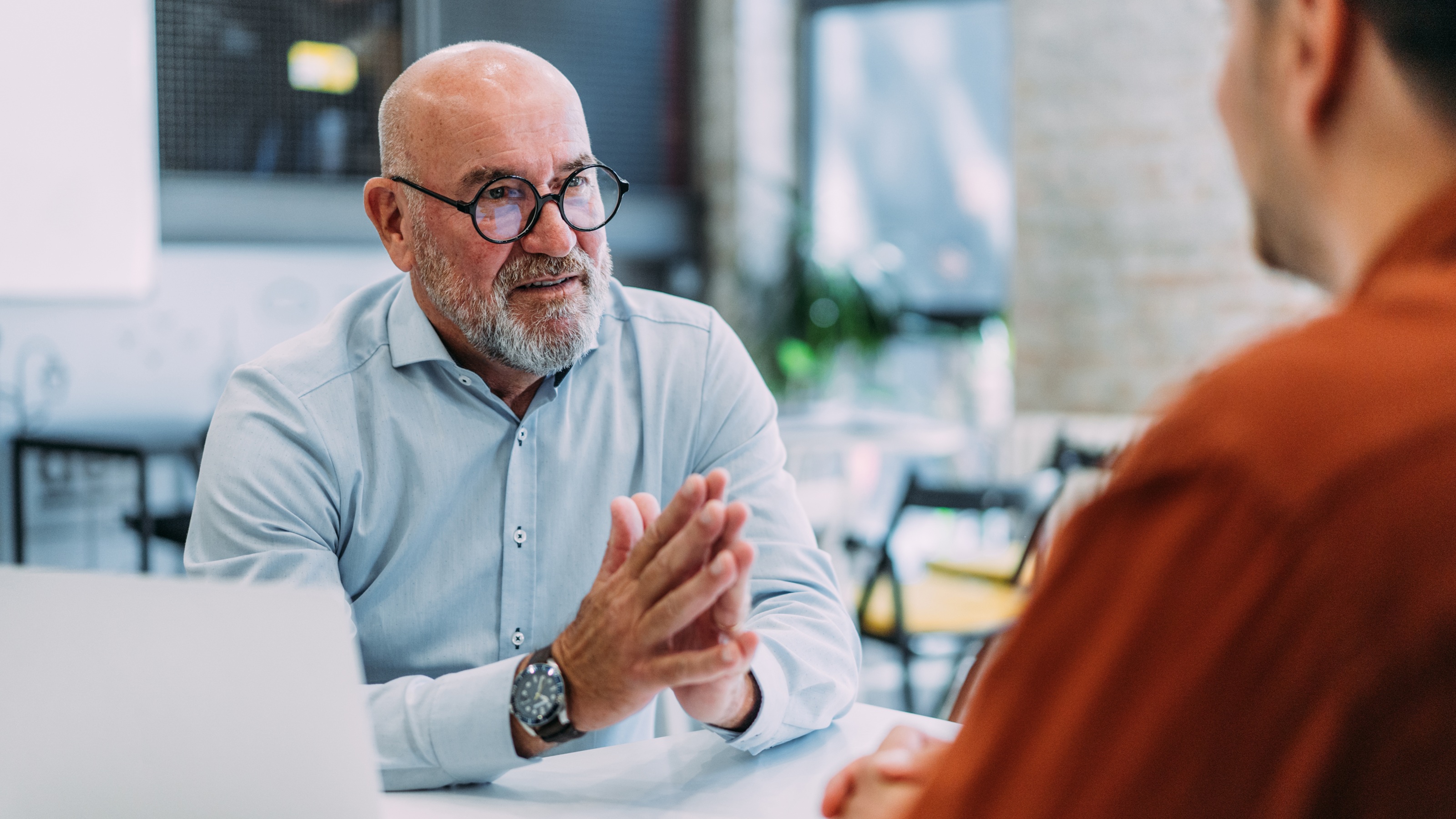 A financial adviser talks intently with a client in his office.