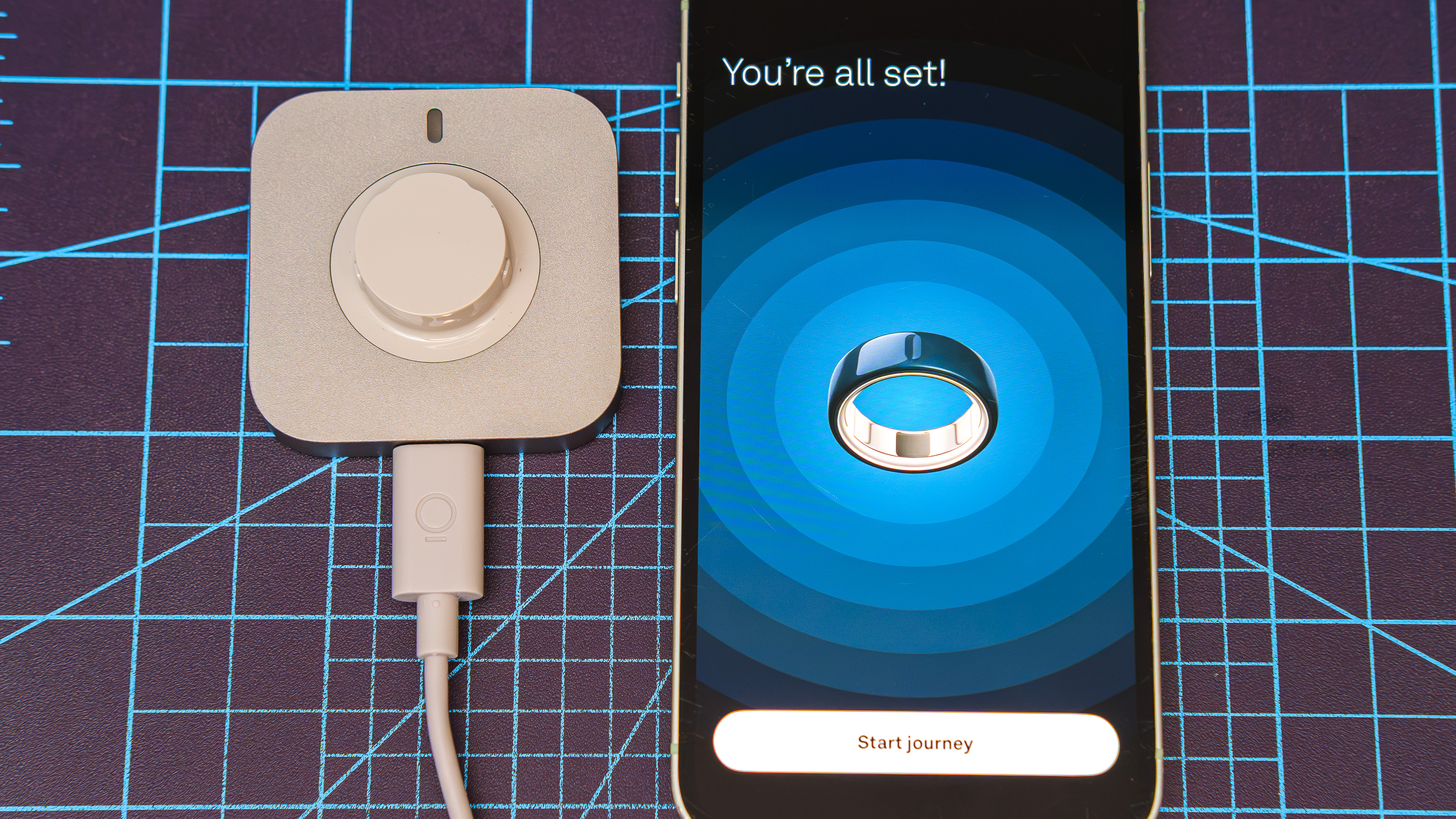 Oura Ring 4 Ceramic close-up showing the setup and pairing process using an iPhone
