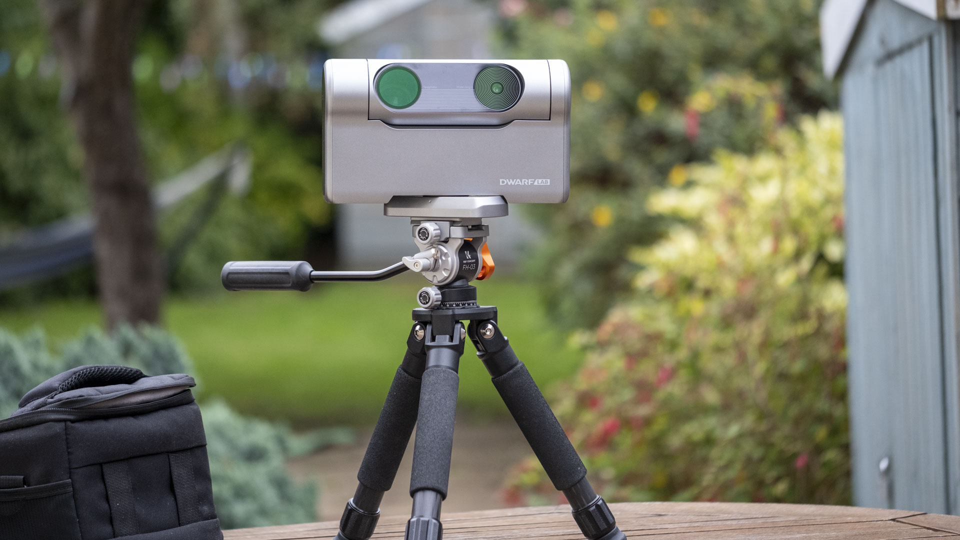 The Dwarf III smart telescope photographed in a garden, showing the front of the device