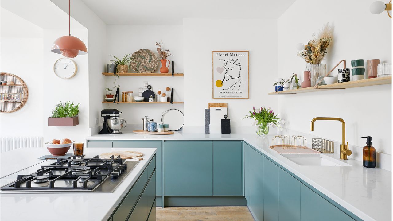 kitchen with white walls, white island with a stove, blue cabinets and wooden shelving with decorative items 