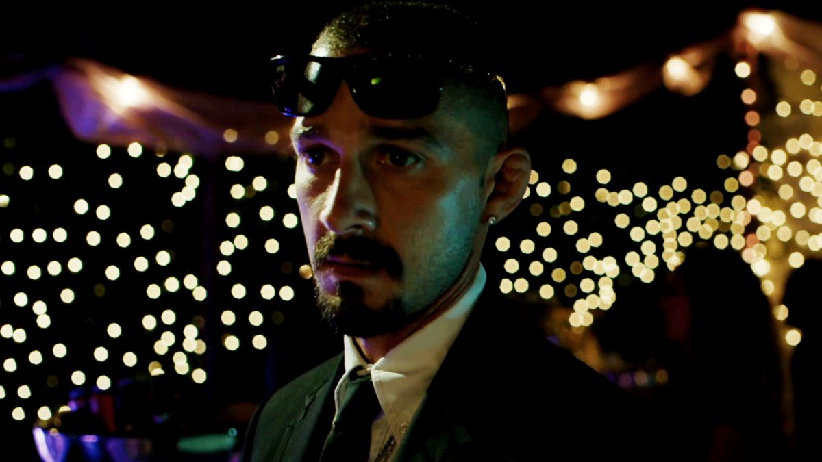 Shia LaBeouf looking worried in the middle of a party scene in The Tax Collector.