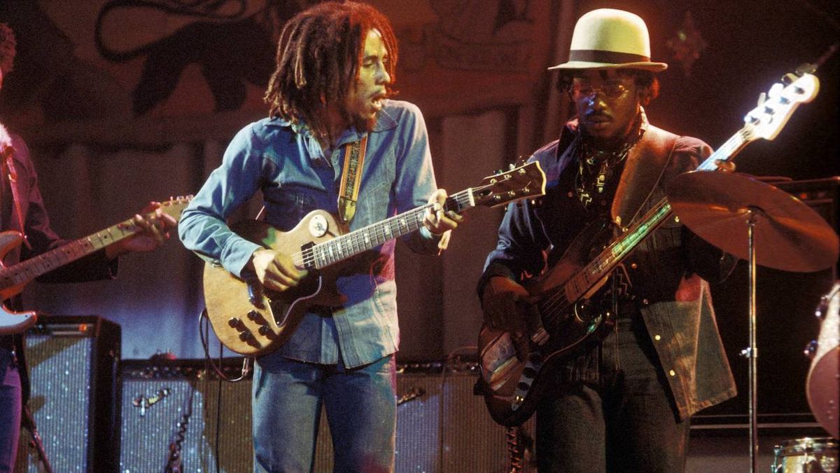 Photo of WAILERS and Aston BARRETT and Bob MARLEY, Bob Marley performing live on stage at the Odeon with Aston &#039;Family Man&#039; Barrett