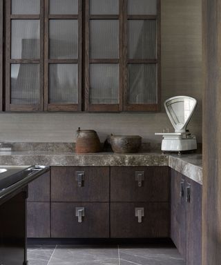 Dark kitchen cabinetry with smokey marble surface