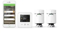 The Drayton Wiser Smart Thermostat and two radiator valves next to a smartphone wit the Drayton Wiser app open