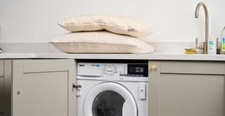 pillows on a kitchen countertop above a washing machine