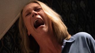 Jamie Lee Curtis screams in anguish by the stairs in Halloween Ends.