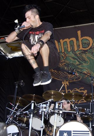 Randy Blythe jumps in the air on stage in 2004