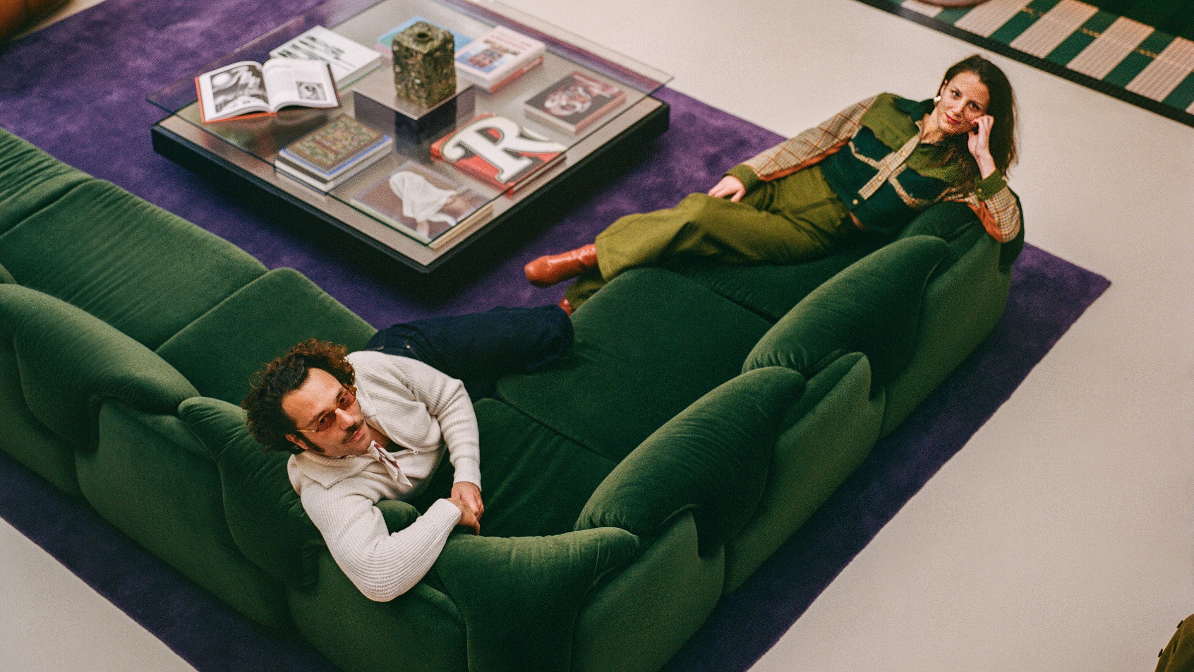 l'atelier ha designers on a green sofa and purple rug