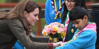 Kate Middleton inspects a scout's merit badges.