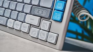 The NuPhy Nos75 mechanical keyboard on a stone surface with a blue background