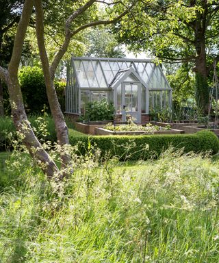 traditional greenhouse surrounded by a vegetable garden