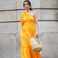 woman wearing orange dress and carrying beach bag