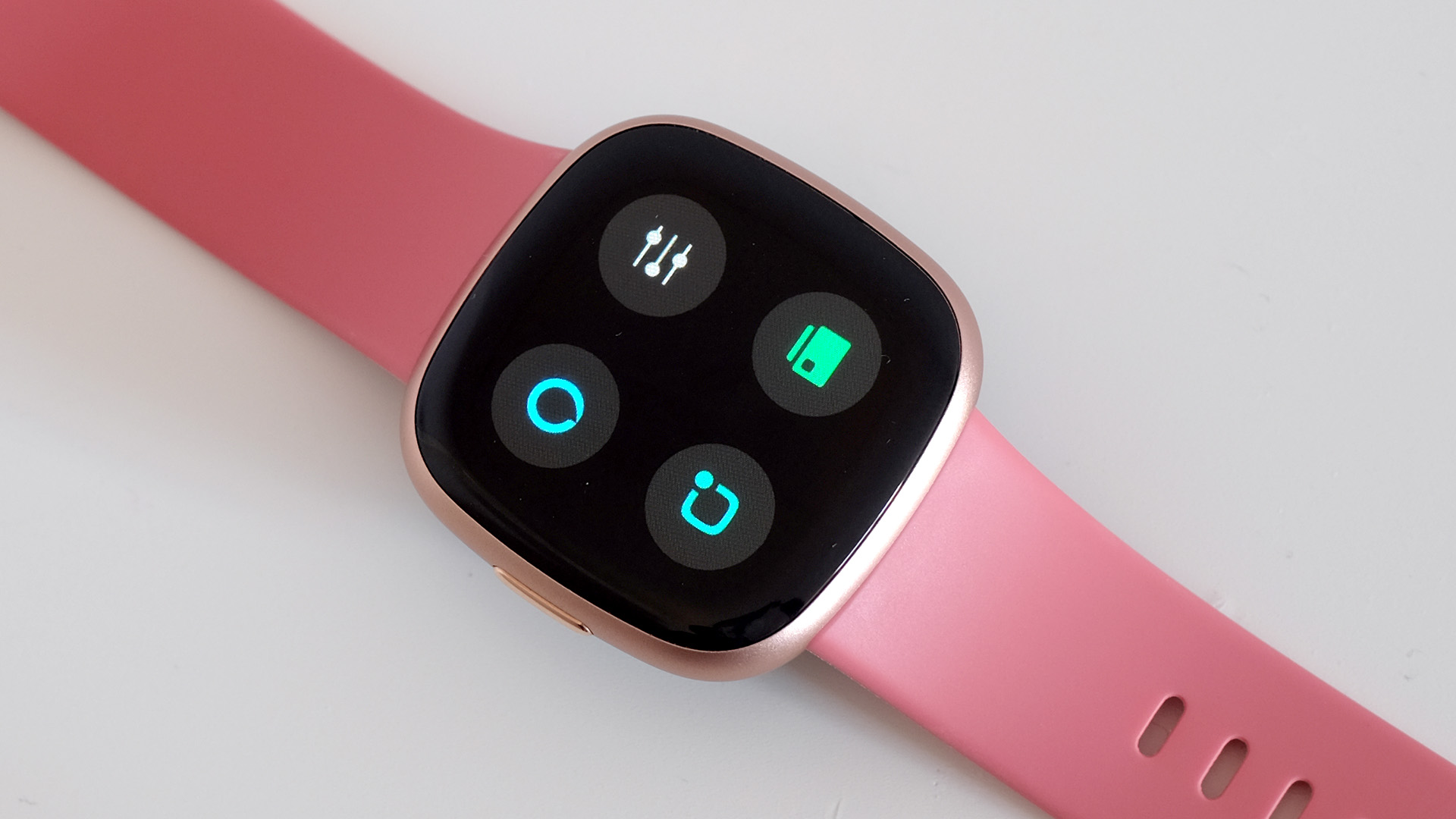 Fitbit Versa 4 with pink strap on white background