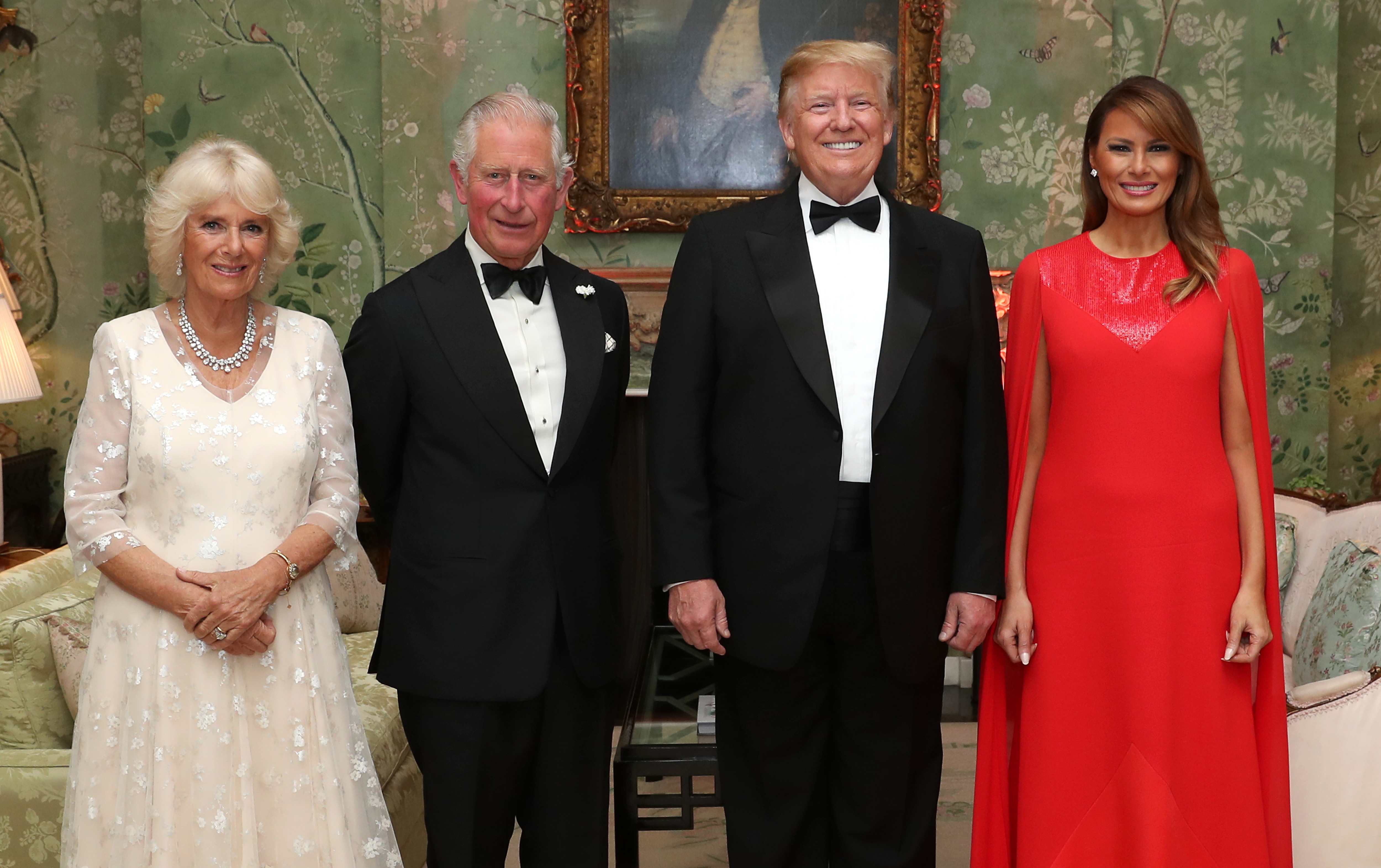 Queen Camilla, King Charles, Donald Trump, Melania Trump wearing gowns and tuxes and smiling next to each other