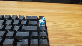 a small cat shaped keycap on a black keyboard