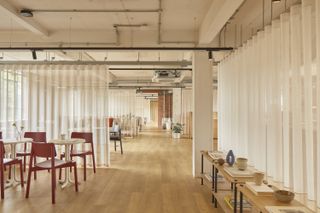 the loom club interiors with timber cladding and soft curtains dividing the space