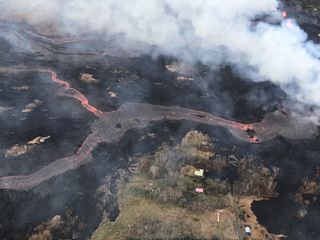 A lava flow emerges from fissure 22 on May 23. Notice how the lava is flowing downhill, from right to left in the photo.